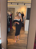 Rochie Celia midi neagra pe corp accesorizata cu perle si maneci bufante