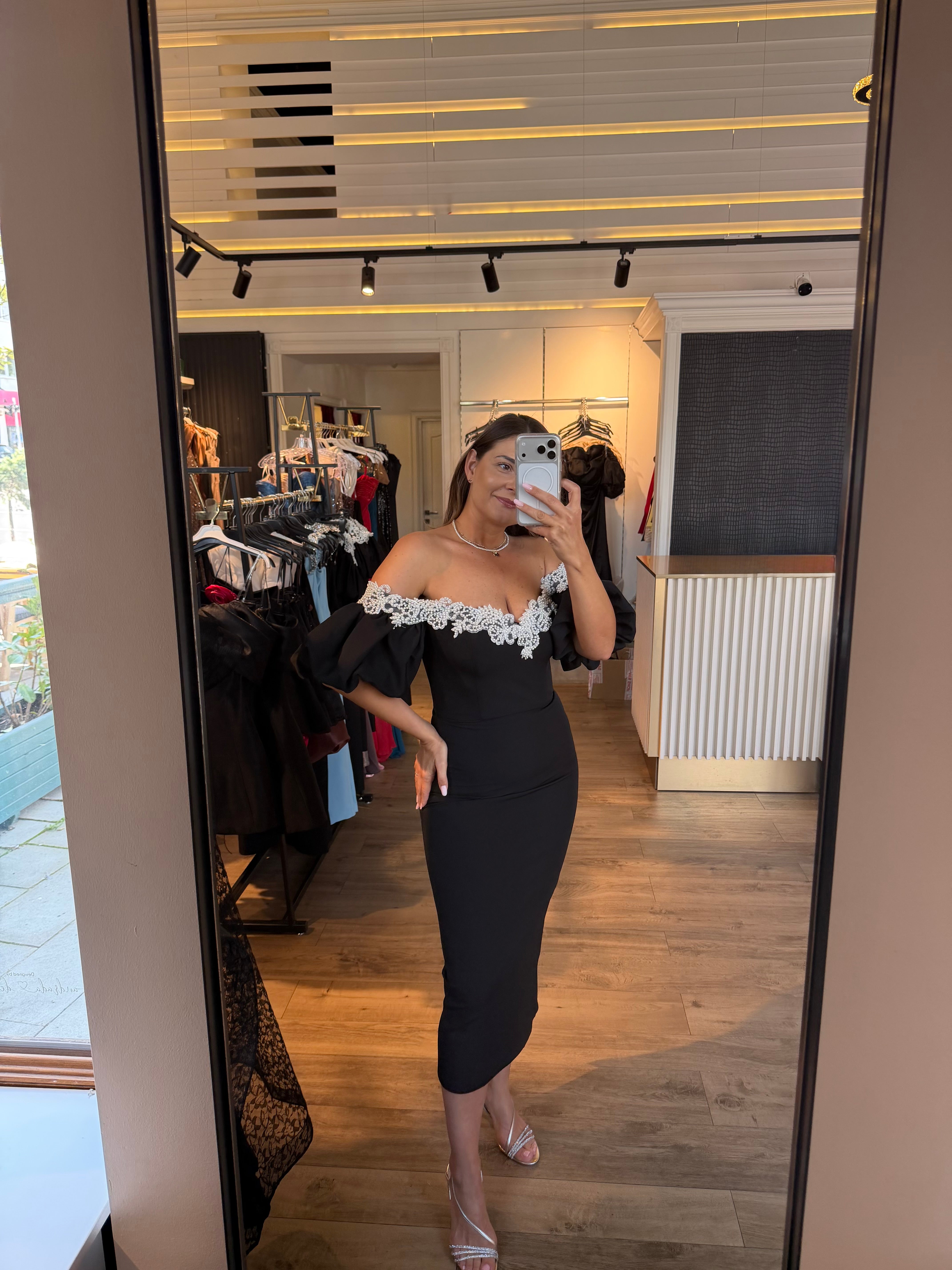 Rochie Celia midi neagra pe corp accesorizata cu perle si maneci bufante