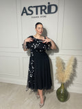 Rochie Sărita midi neagră, cu aplicații strălucitoare și design asimetric.