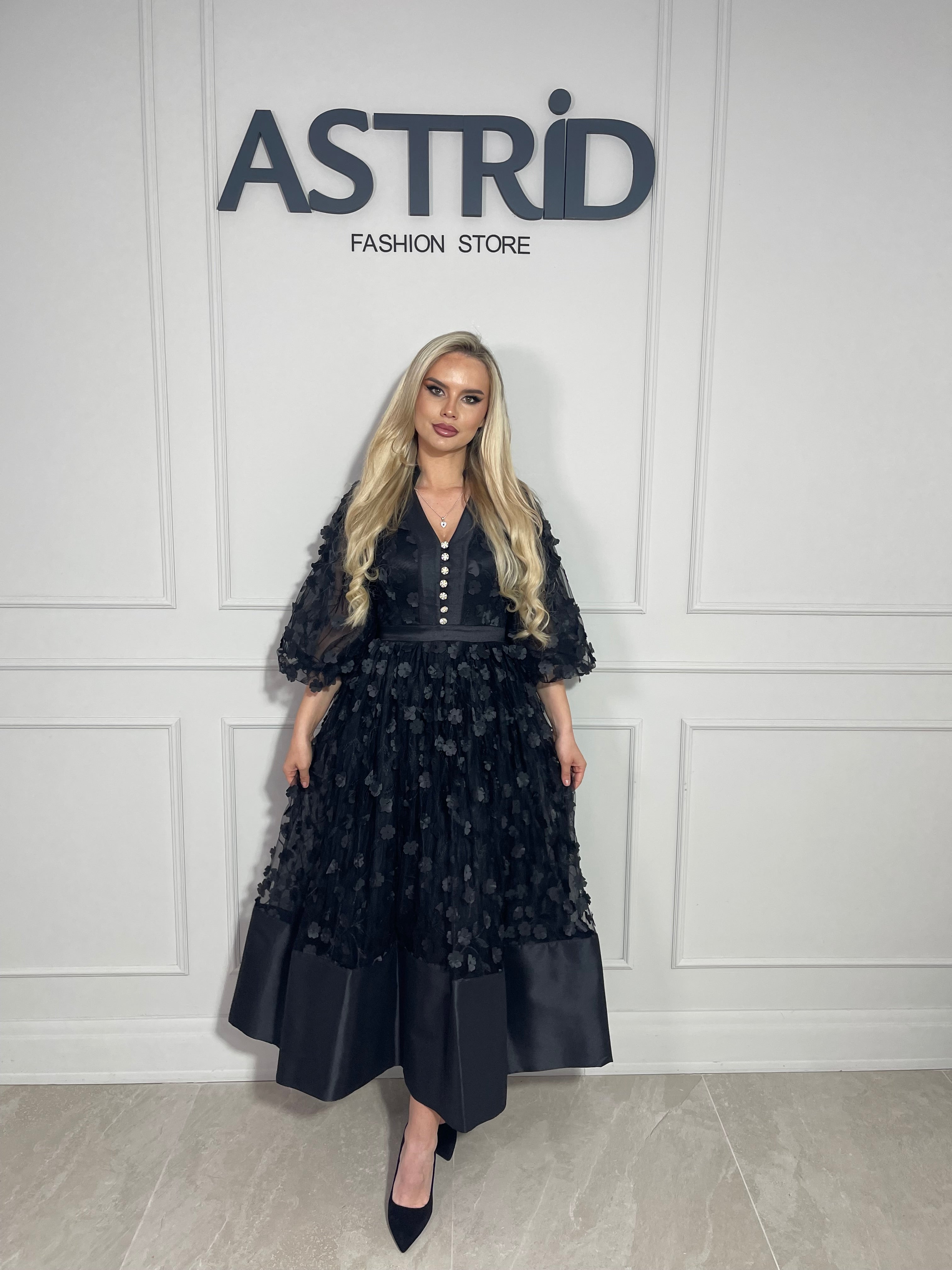 Rochie Capri, midi neagră, cu croiala lejeră și talie marcată.