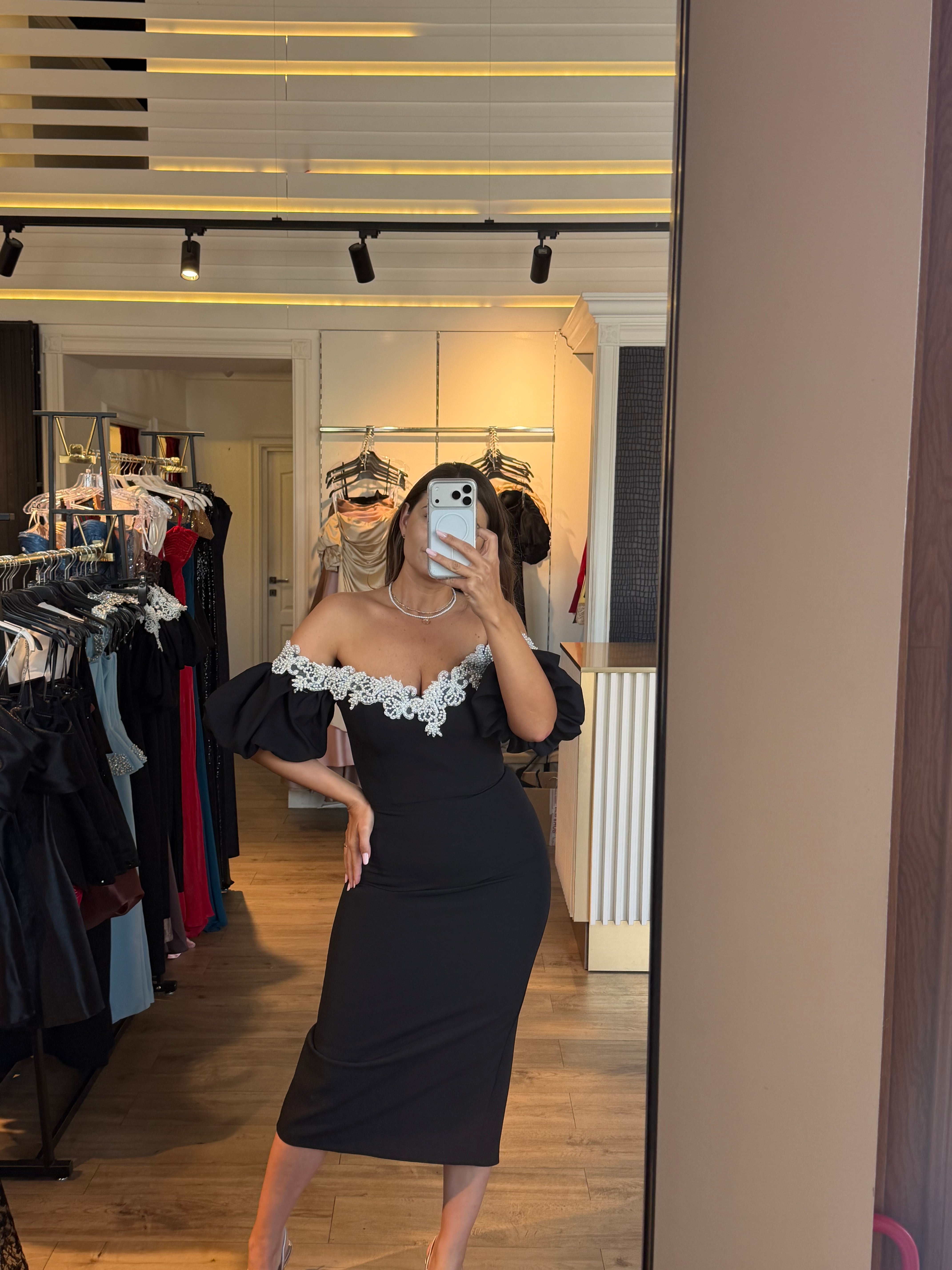 Rochie Celia midi neagra pe corp accesorizata cu perle si maneci bufante
