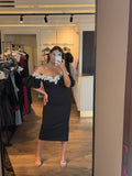 Rochie Celia midi neagra pe corp accesorizata cu perle si maneci bufante