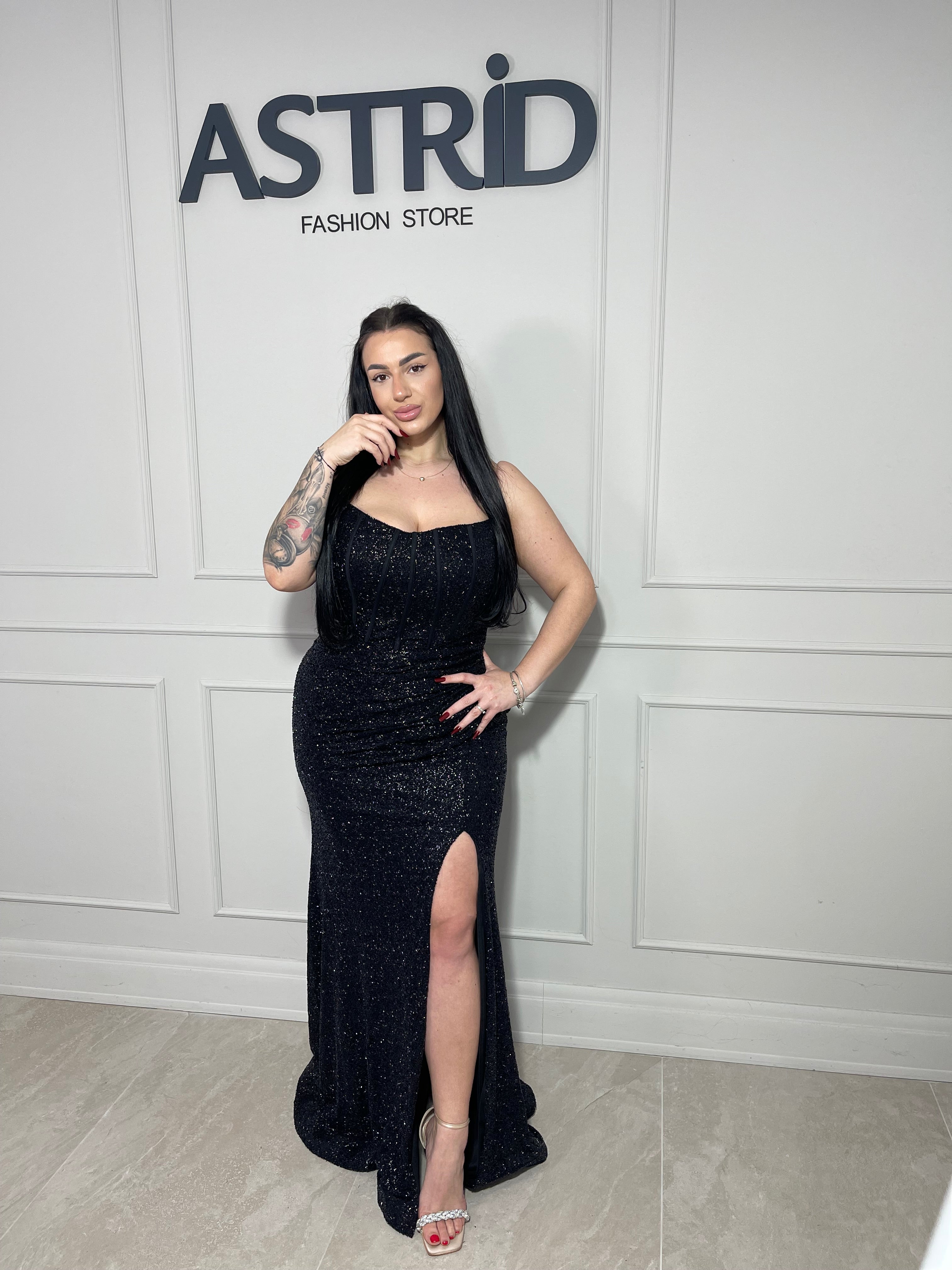 Rochie Any lungă, neagră cu accente aurii și inserții de sclipici, ce oferă un efect elegant și sofisticat.