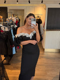 Rochie Celia midi neagra pe corp accesorizata cu perle si maneci bufante