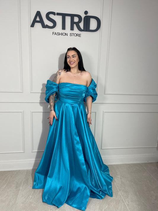 Rochie Lora lungă, intr-un albastru deschis delicat, cu umeri goi ce subliniază eleganța și feminitatea.