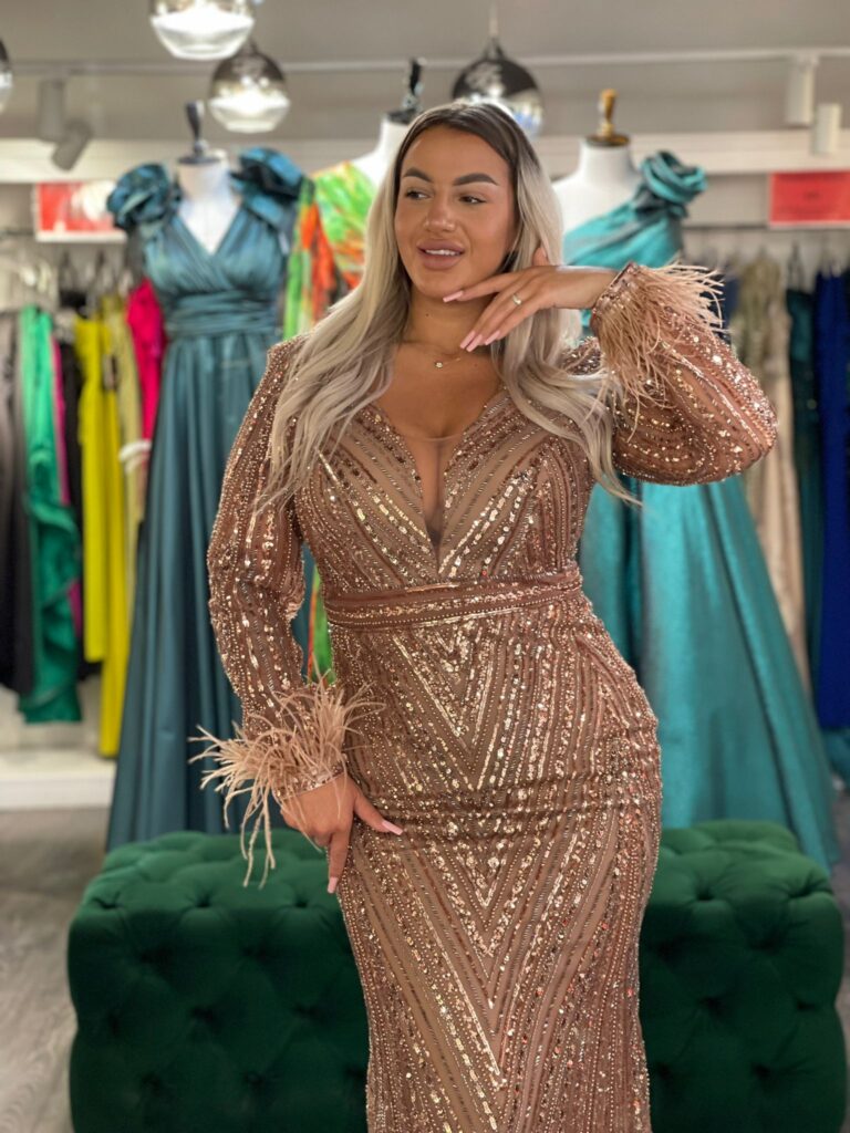 Rochie Cleopatra lunga din paiete cu maneca lunga accesorizata cu pene si sclipici.